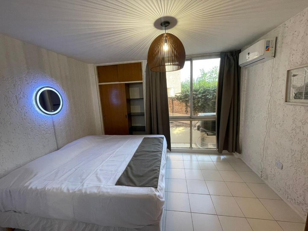 a bedroom with a bed and a large window at Departamento en Nueva Córdoba in Cordoba