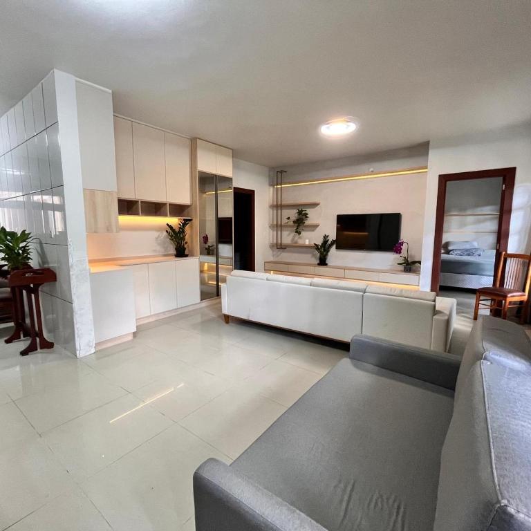 a large living room with a couch and a kitchen at Casa do vivi 1 in Tramandaí