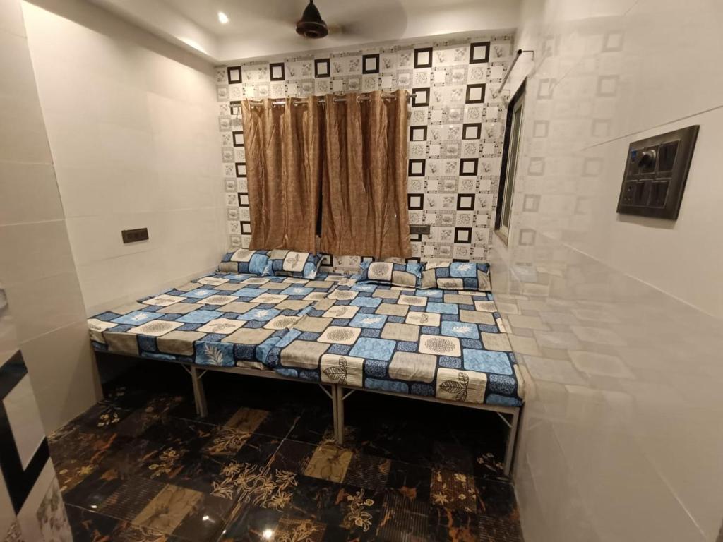 ein kleines Bett in einem Zimmer mit Fenster in der Unterkunft HOTEL IN UJJAIn in Ujjain