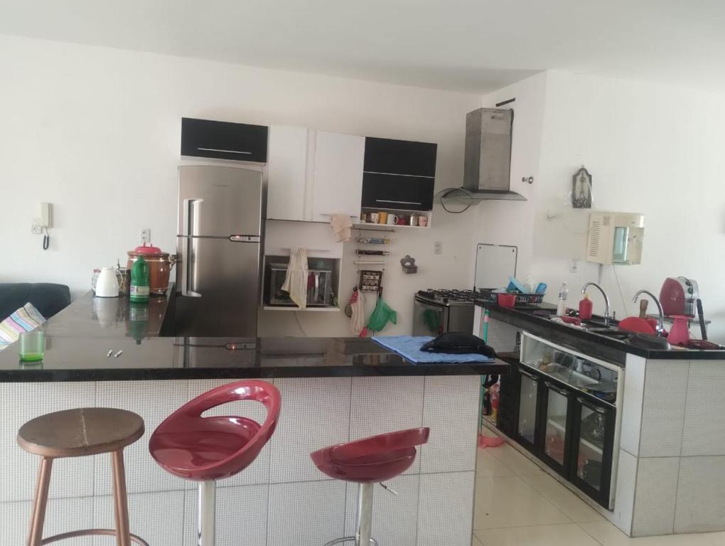 een keuken met twee rode krukken en een aanrechtblad bij Casa Mussurunga in Salvador
