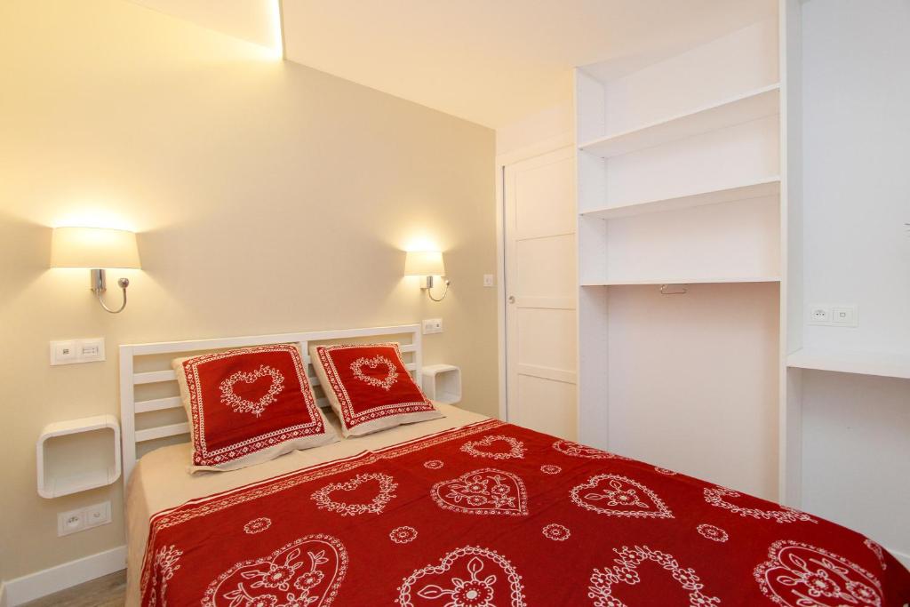 a bedroom with a red bed with two pillows at Le 24 in Les Deux Alpes