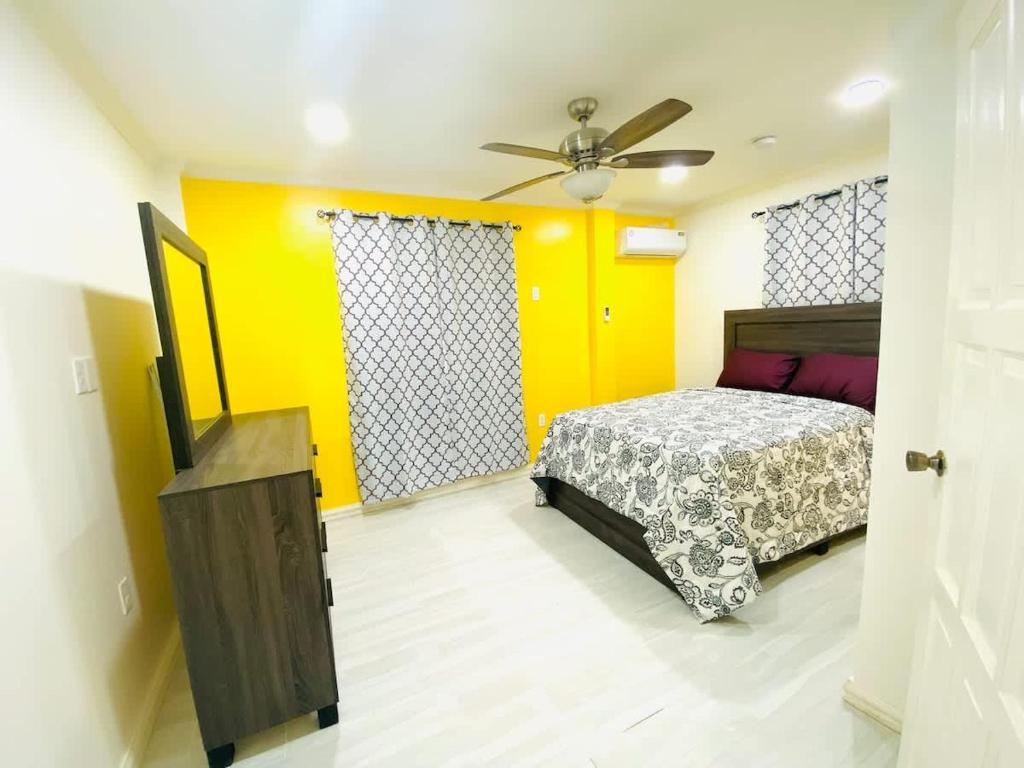 a bedroom with a bed and a yellow wall at Gentlemen's Suite - 3 Bedroom in Beterverwagting