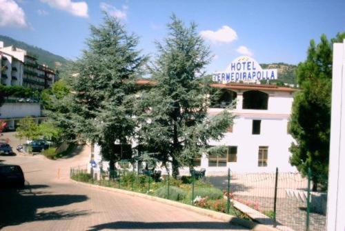 Un bâtiment blanc avec un panneau en haut dans l'établissement Terme Di Rapolla, à Rapolla