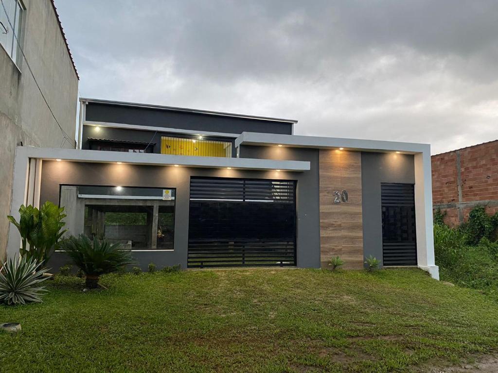 ein modernes Haus mit Rasen davor in der Unterkunft Casa de Praia na Roça in Angra dos Reis