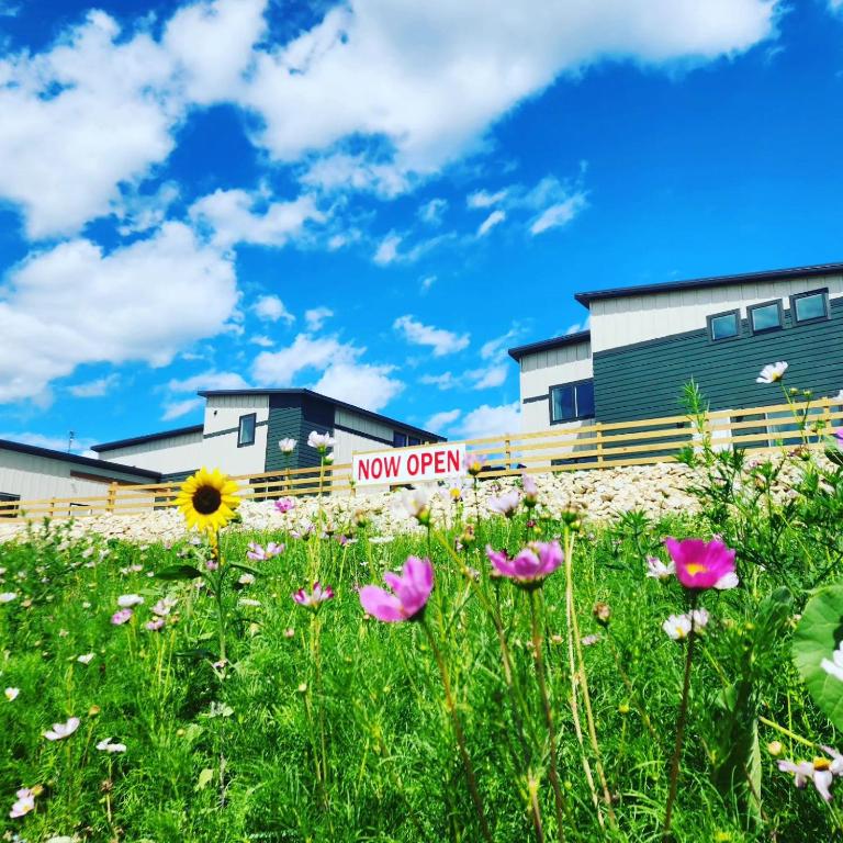 a field of flowers in front of a new open sign at Bluffside Gardens in Decorah