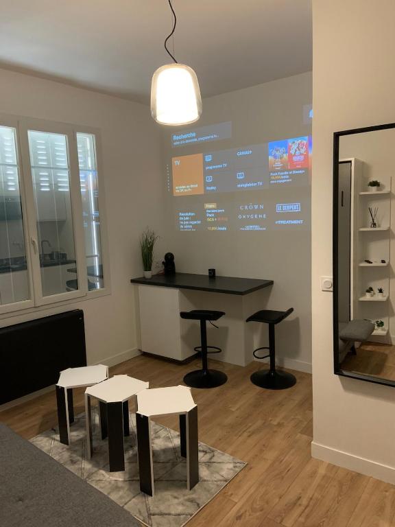 Cette chambre dispose d'une table, de tabourets et d'un grand écran. dans l'établissement La Suite Dream - GURVAND - Confort - Centre Ville, à Rennes