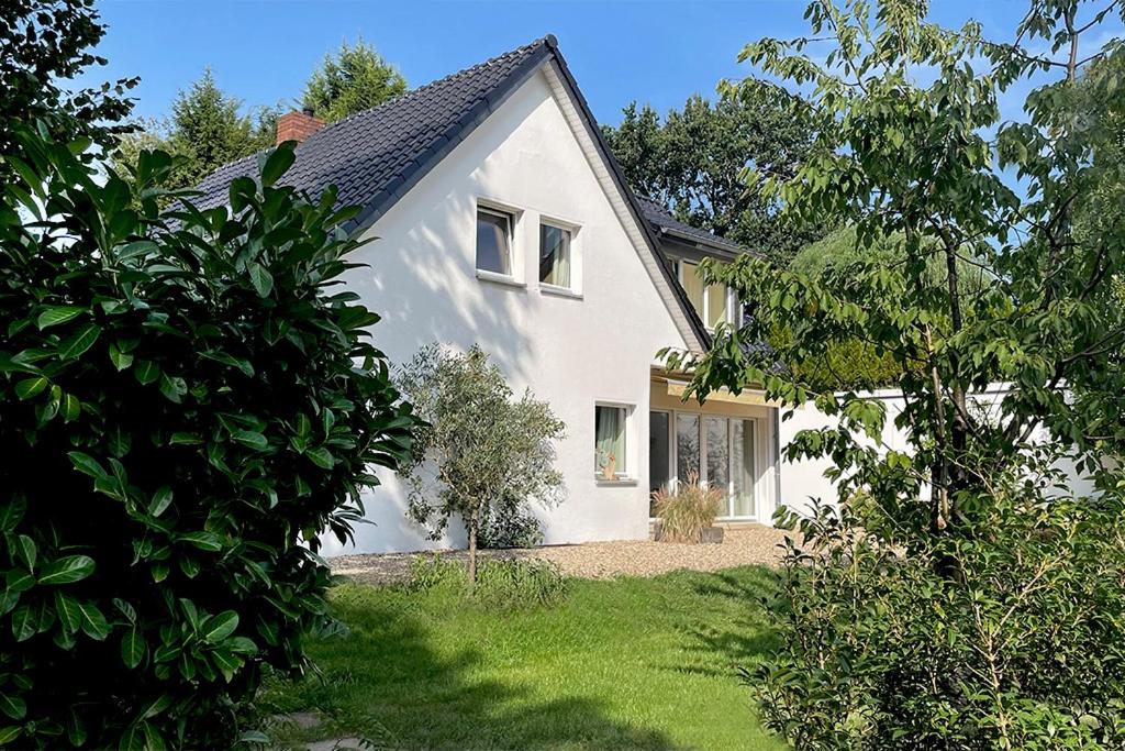 a white house with a yard at Landhaus Meerbusch bei Düsseldorf in Meerbusch