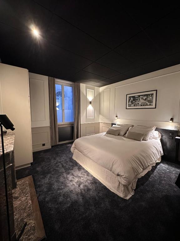 une chambre avec un grand lit et une fenêtre dans l'établissement Suite Junior, à Saint-Brieuc