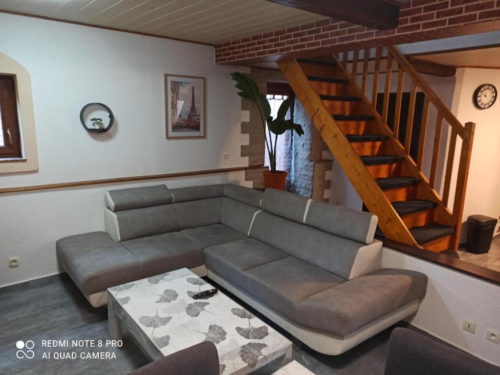 un salon avec un canapé et un escalier dans l'établissement Maison jumelée, à Wittenheim