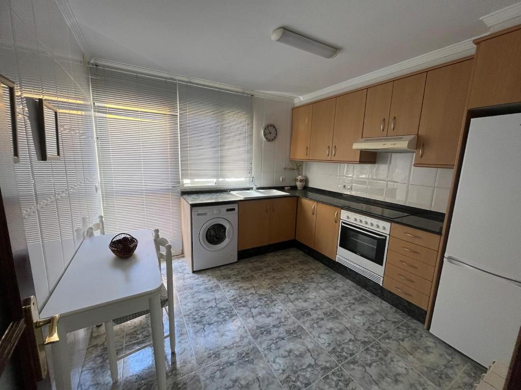 a kitchen with wooden cabinets and a washer and dryer at Casa Roma in Casinos