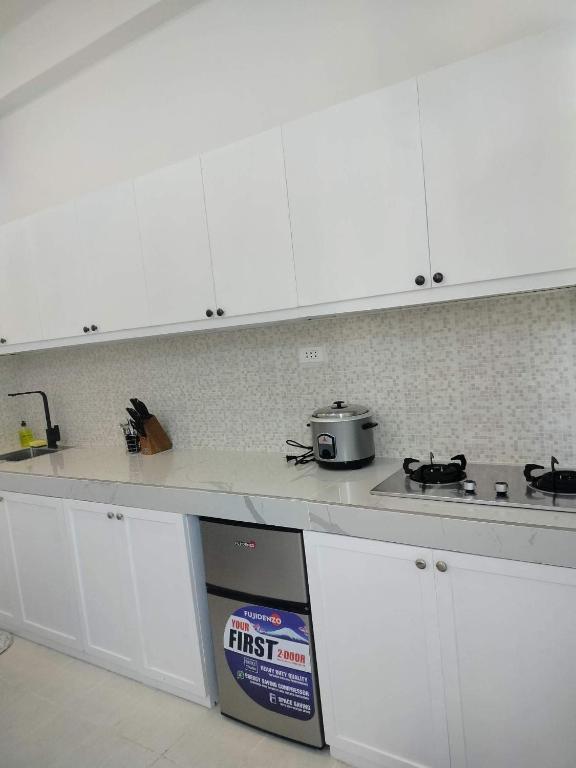 a kitchen with white cabinets and a pot on a stove at Dajon #7 Superior STE-Generator & Starlink in General Luna