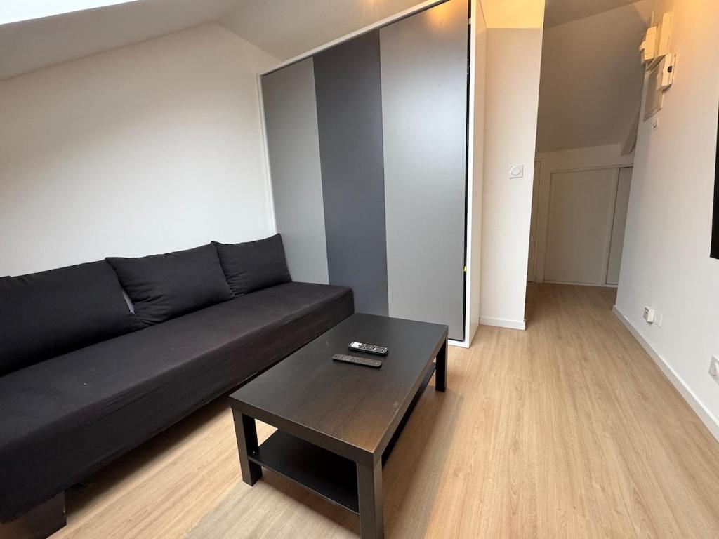 - un salon avec un canapé noir et une table basse dans l'établissement 5-star La Suite - 30D rue Général Margueritte, à Rennes
