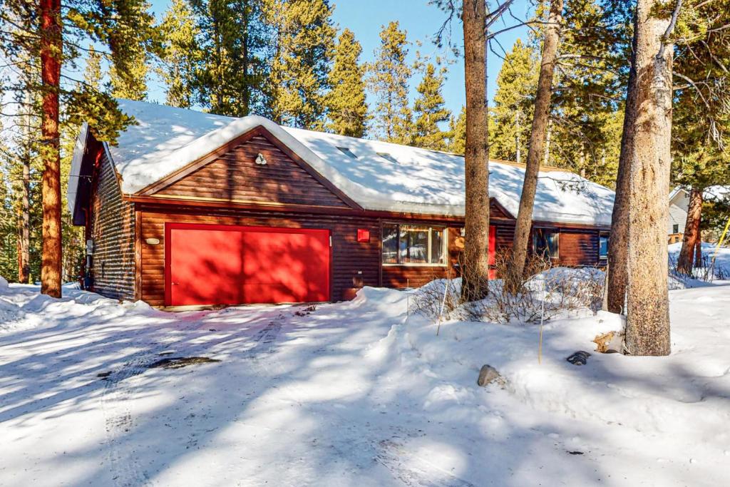 a log cabin in the snow with a red garage at Ollie's Place in Breckenridge