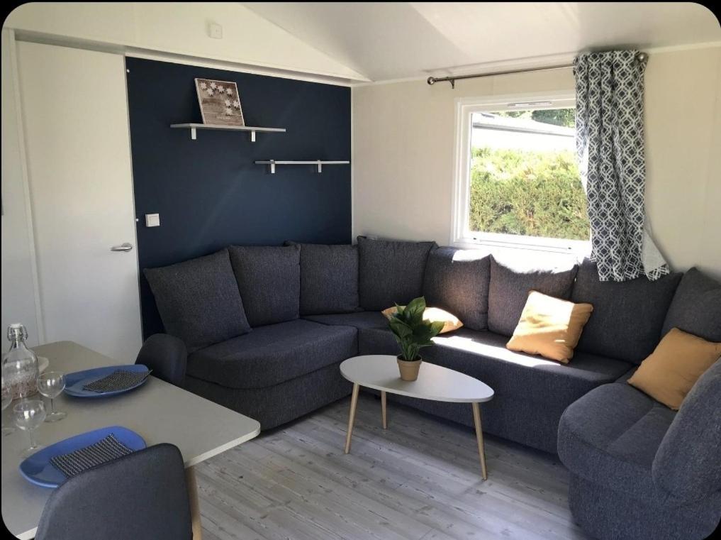un salon avec un canapé et une table dans l'établissement Mobile home CAMPING LES MATHES 8 personnes, aux Mathes