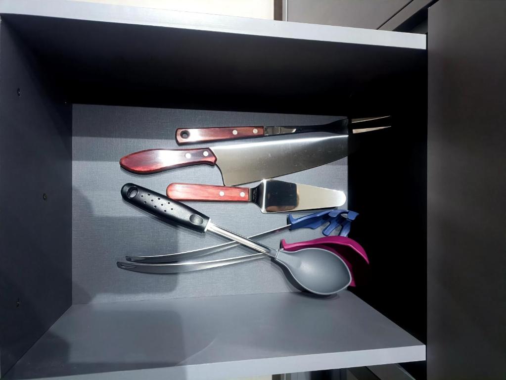 a black box filled with cooking utensils on a shelf at Residencial Acquamare in Praia Grande