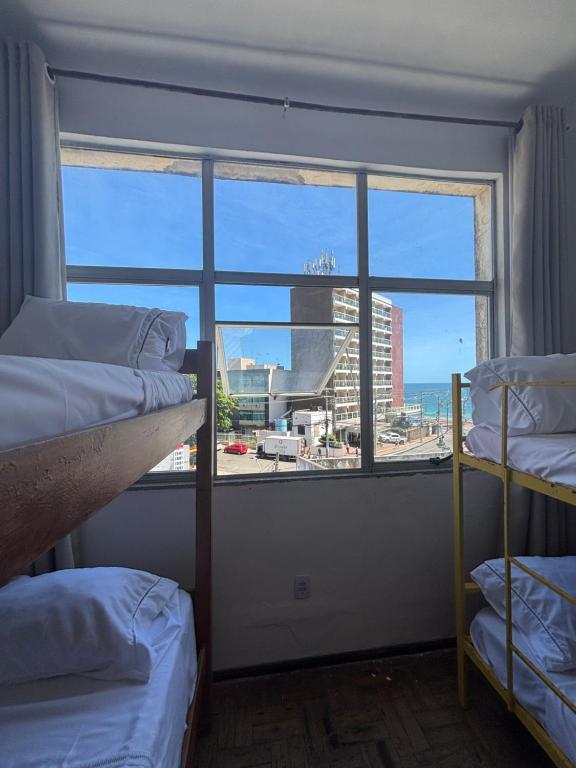 a room with two bunk beds and a large window at Barra Mar in Salvador