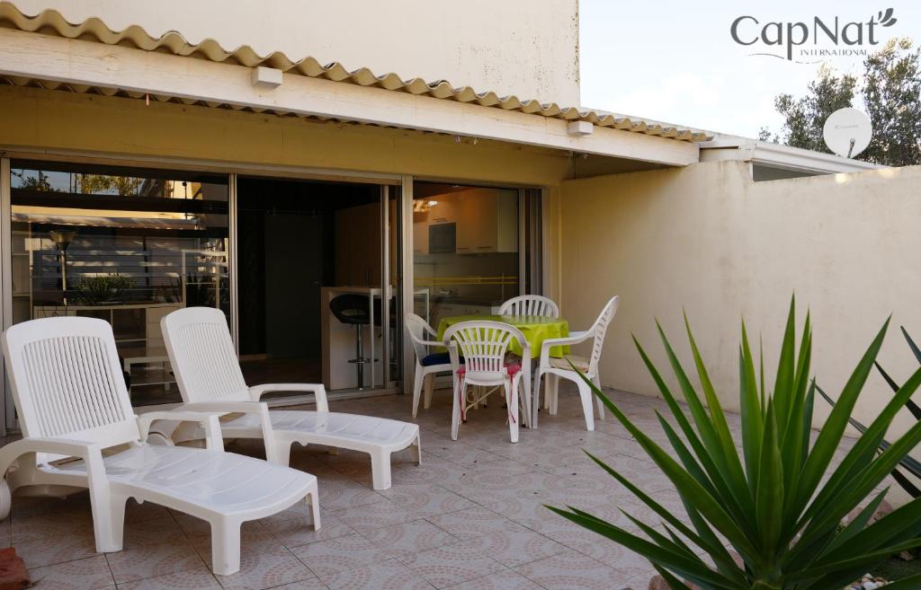 un groupe de chaises et de tables sur une terrasse dans l'établissement CapNat - Village Naturiste - Port Nature - Villa Dolce Vita, au Cap d'Agde