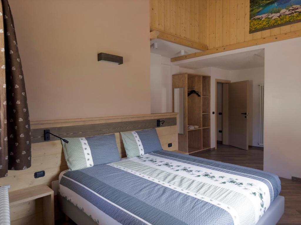 a bedroom with a large bed with blue sheets at Appartamenti LITEGOSA casa vacanza 3 in Panchia