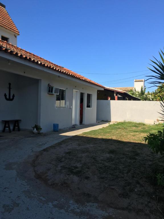a white house with a yard in front of it at Hostel Caminho do Atlântico in Arraial do Cabo