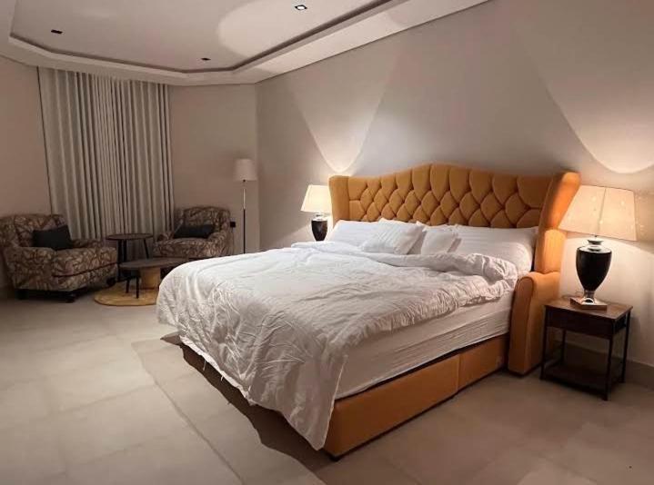 a bedroom with a large bed and a chair at الريمية in Al Madinah