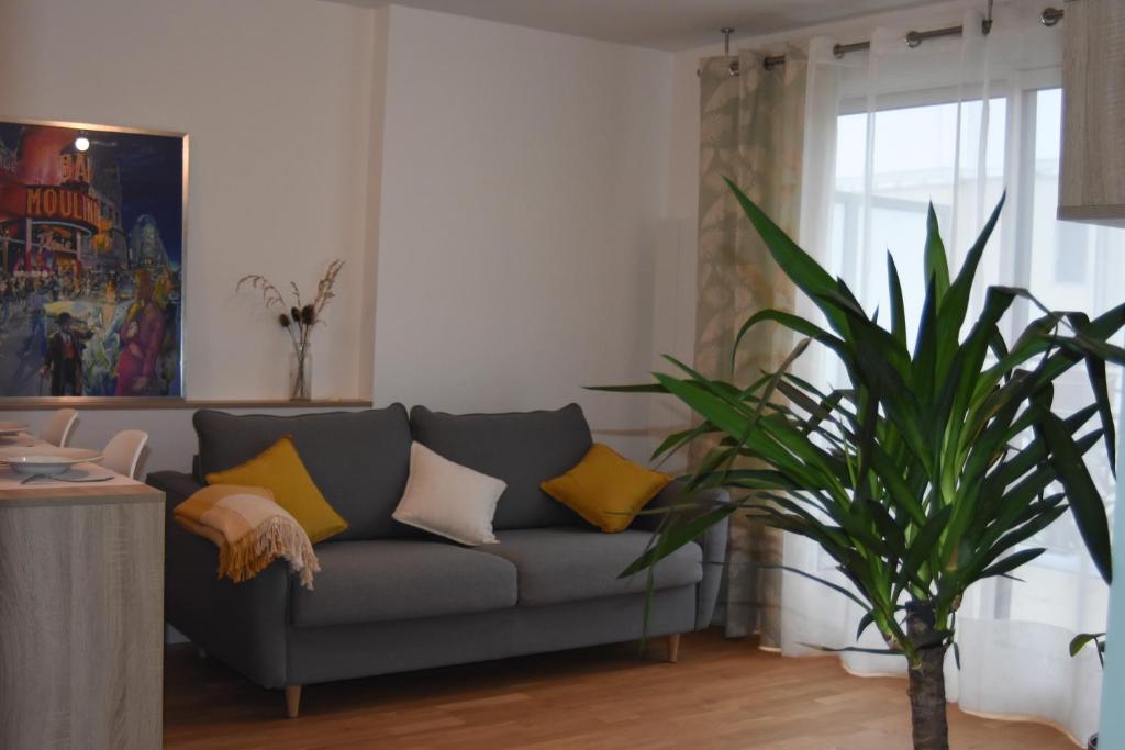 un salon avec un canapé et une plante dans l'établissement Villa Angélina, à Saint-Cyr-lʼÉcole