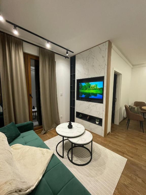 a living room with a green couch and a table at Green Apartment&Spa in Zlatibor