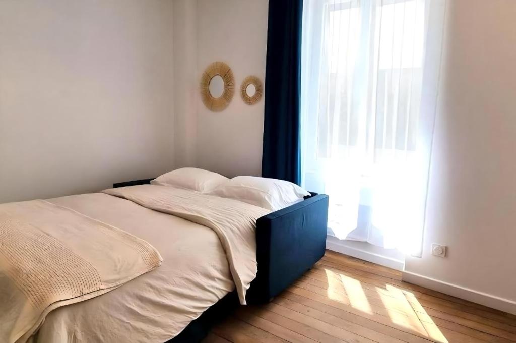 a bed in a room with a large window at Studio Flaubert lumineux tout confort in Châteauroux
