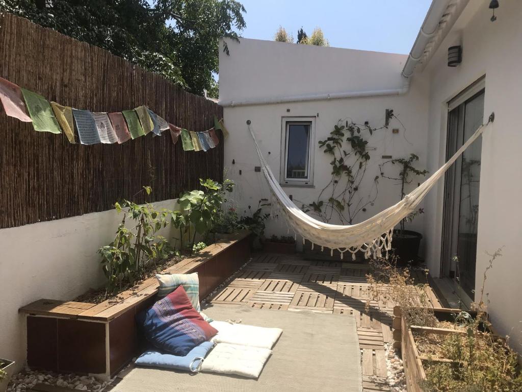 a hammock in a backyard with a fence at Casa da Rita in Cascais