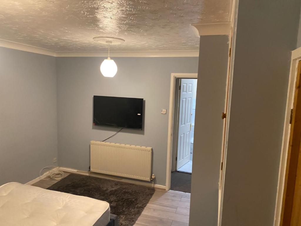 a bedroom with a bed and a flat screen tv at Home in Wednesbury