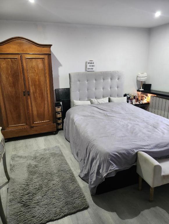 - une chambre avec un grand lit et une armoire en bois dans l'établissement Strasbourg centre proche gare, à Strasbourg