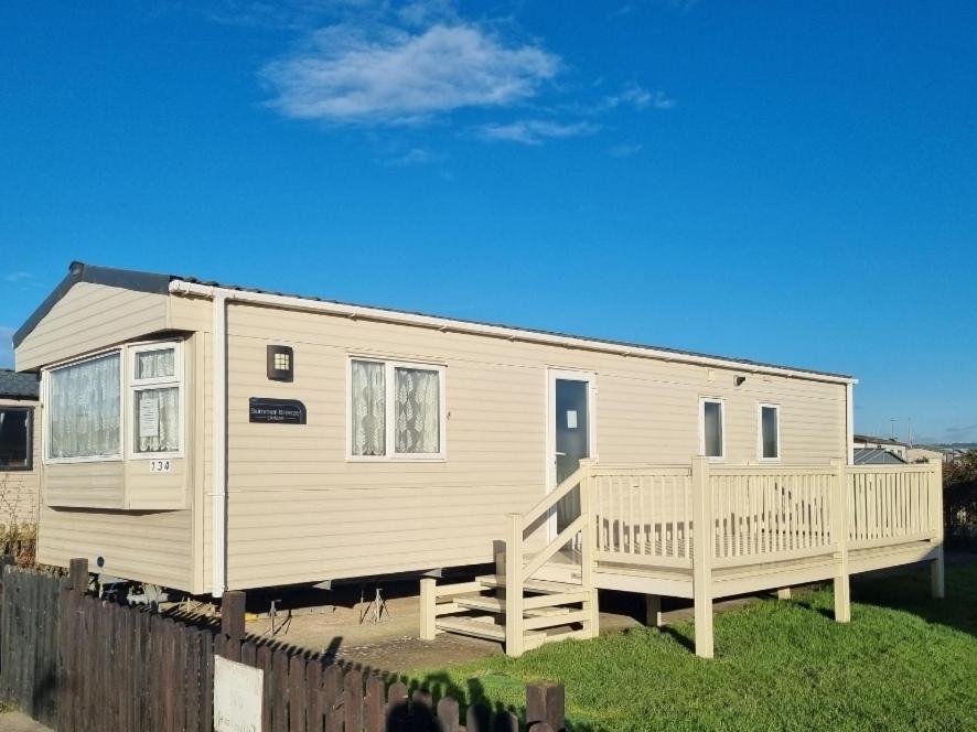 ein kleines Haus mit einer Veranda und einer Terrasse in der Unterkunft Spacious and modern - 134 UNITY BEACH HOLIDAY RESORT UNITY BREAN CENTRALLY LOCATED 6 birth 2 Pets stay free in Brean