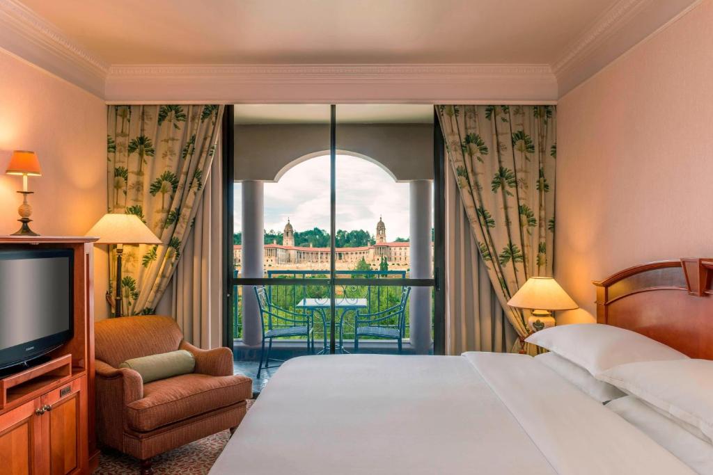 a hotel room with a bed and a large window at CT Hotel in Pretoria