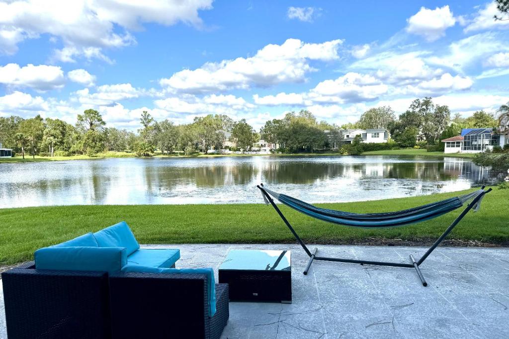 a hammock and chairs in front of a lake at Golf and Tennis ~ Edgewater Escape in Wesley Chapel