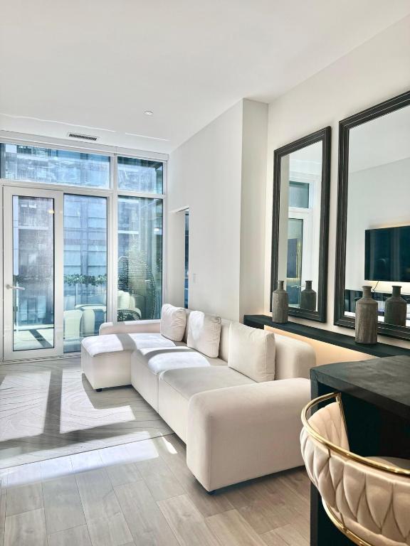 a living room with a white couch and large windows at Toronto Downtown Core Condo 2 BED 2 BATH in Toronto