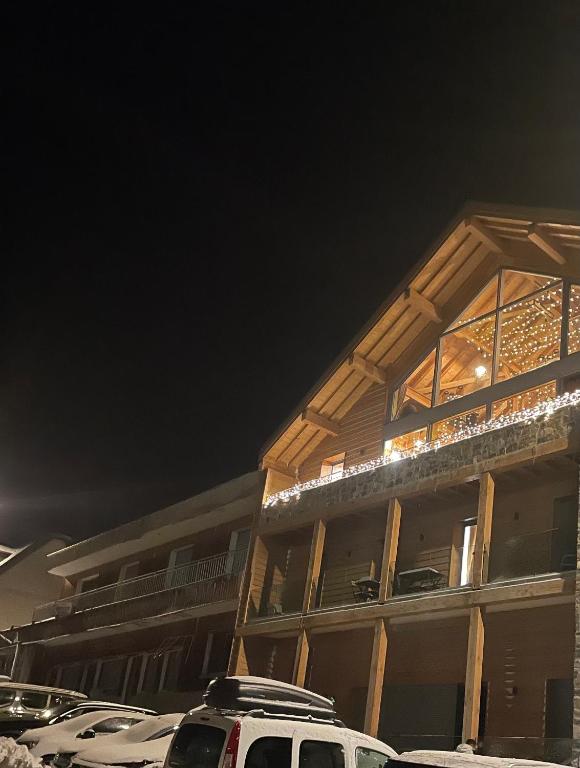 un bâtiment avec des voitures garées devant lui la nuit dans l'établissement Apparemment choucas, à Bagnères-de-Bigorre