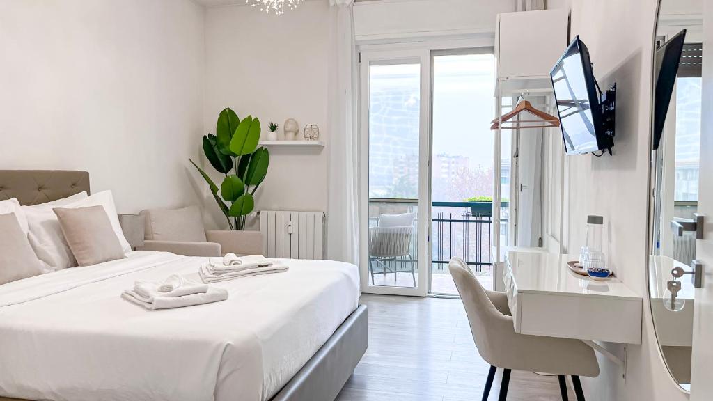 a white bedroom with a bed and a desk and a tv at Dream & Relax in San Donato Milanese