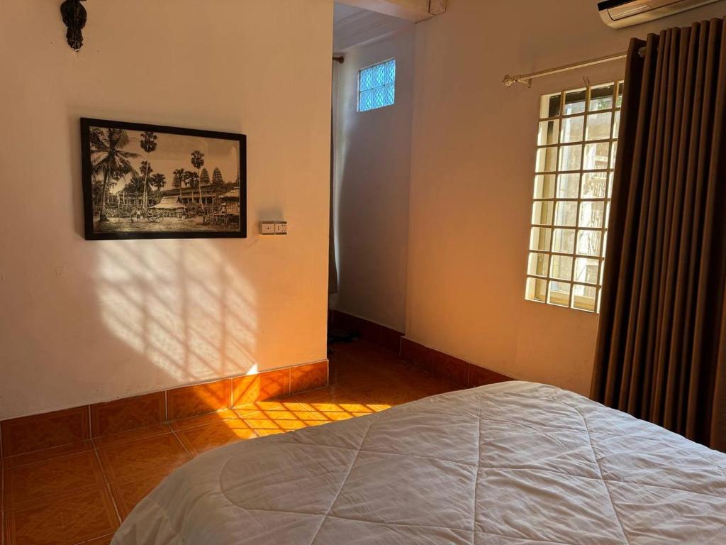 Postel nebo postele na pokoji v ubytování Namo Angkor Villa