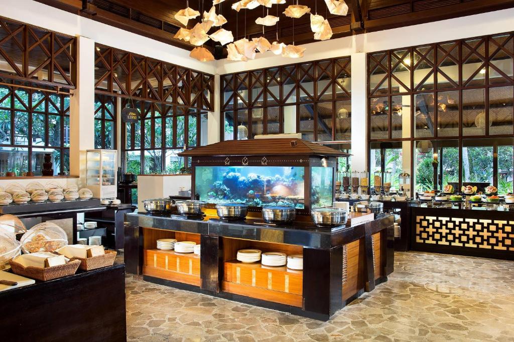 a restaurant with a buffet with a fish tank at Sheraton Senggigi Beach Resort in Senggigi