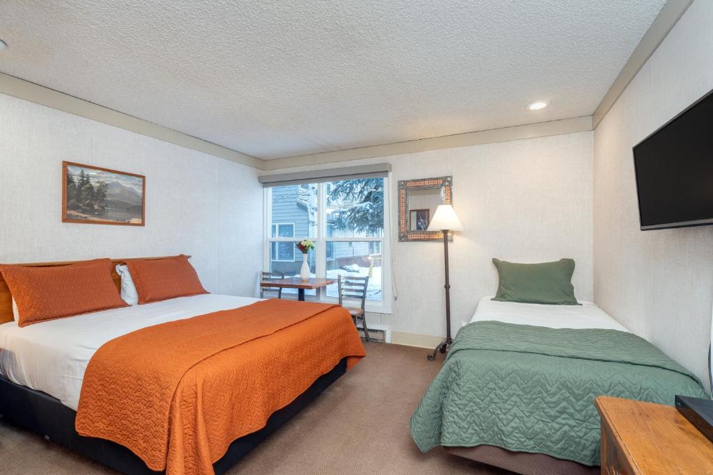 a bedroom with two beds and a window at Mountainside Inn 406 by Alpine Lodging Telluride in Telluride