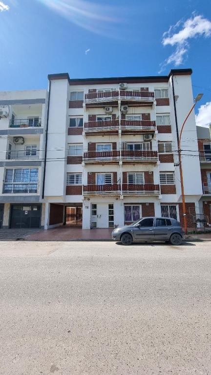 a car parked in front of a large building at Depto Velez Sarsfield in Cipolletti