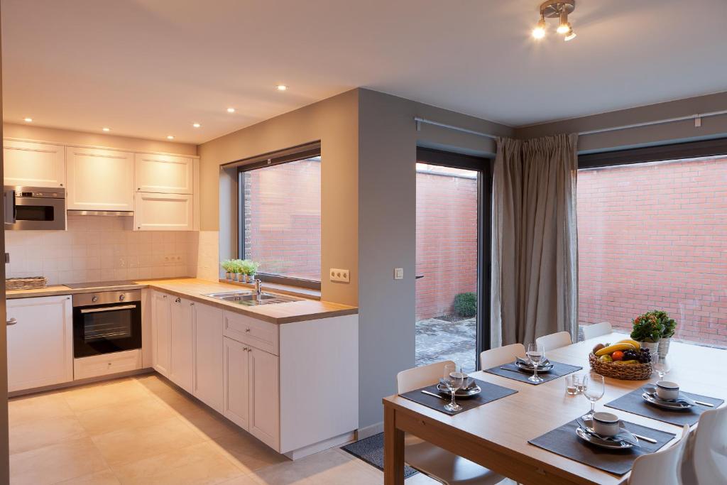 a kitchen and dining room with a table and chairs at FLY in POPS in Poperinge