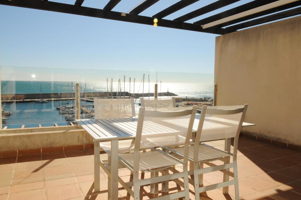 a table and chairs on a balcony with a view of the ocean at Residencial Marina de Port in L'Ametlla de Mar