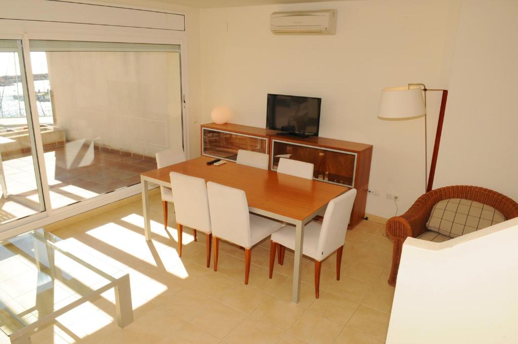a dining room with a wooden table and chairs at Residencial Marina de Port in L'Ametlla de Mar