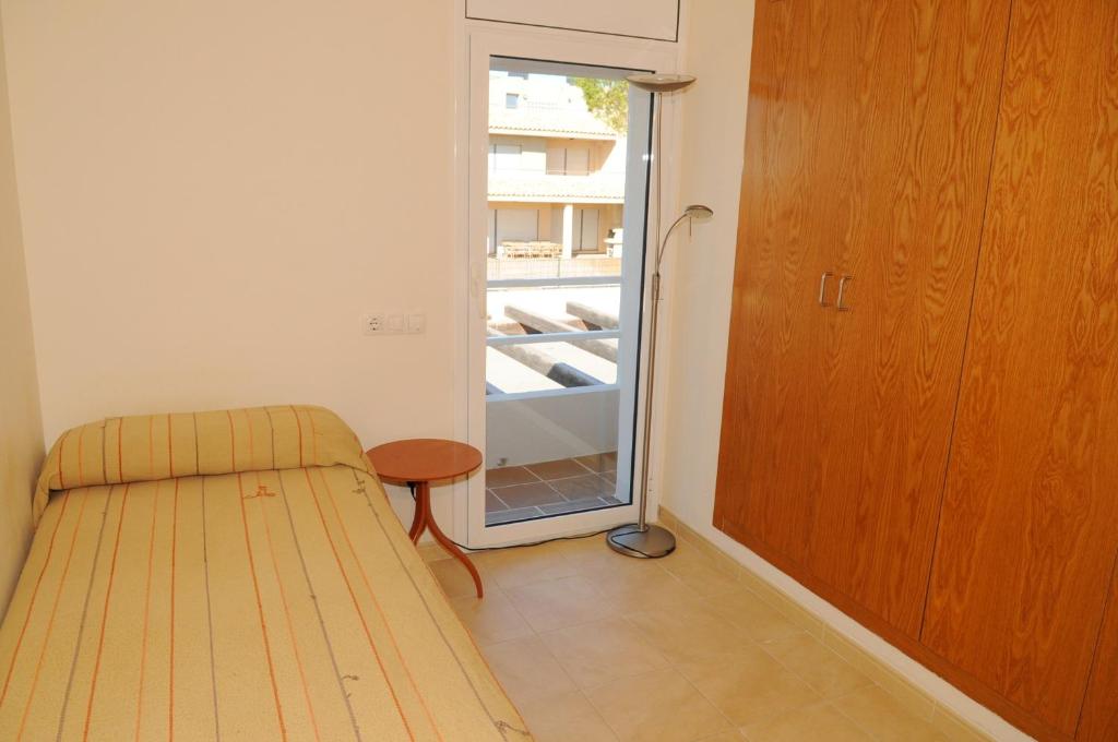 a bedroom with a bed and an open refrigerator at Residencial Marina de Port in L'Ametlla de Mar