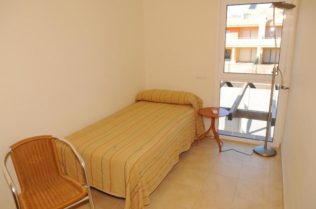 a small room with a bed and a window at Residencial Marina de Port in L'Ametlla de Mar