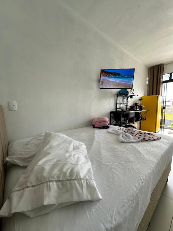 una camera con letto bianco e TV a parete di Pousada Mar e Chaves a Penha