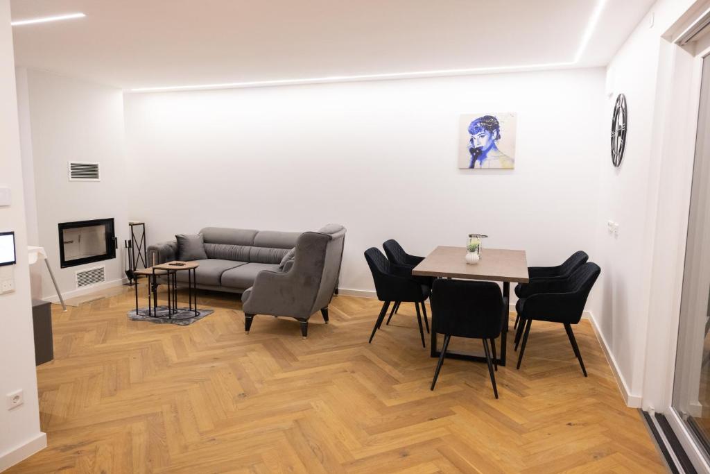 ein Wohnzimmer mit einer Couch und einem Tisch und Stühlen in der Unterkunft Neubau Apartment mit Kamin und Terrasse in Premium Lage Parkplatz inklusive in Bielefeld