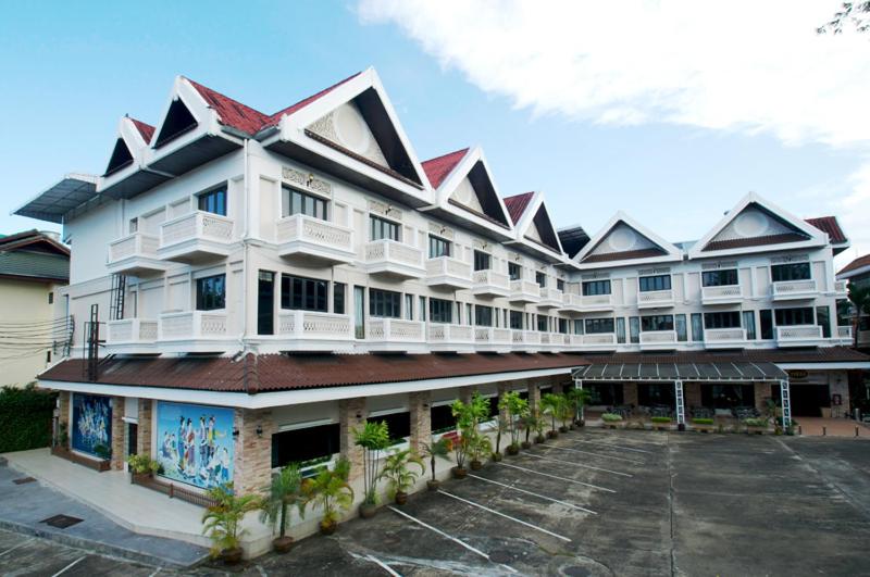 a large white building with a parking lot at Vista Hotel Chiang Mai - SHA EXTRA PLUS in Chiang Mai