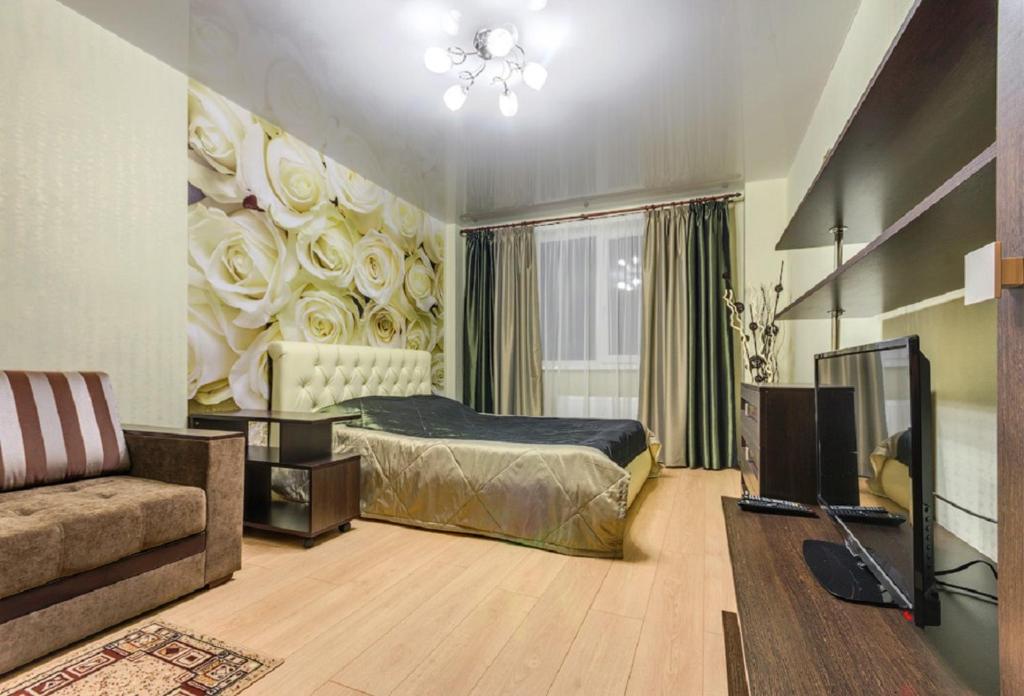 ヴォロネジにあるATLANT Apartments 106のベッドルーム(ベッド1台、ソファ、テレビ付)