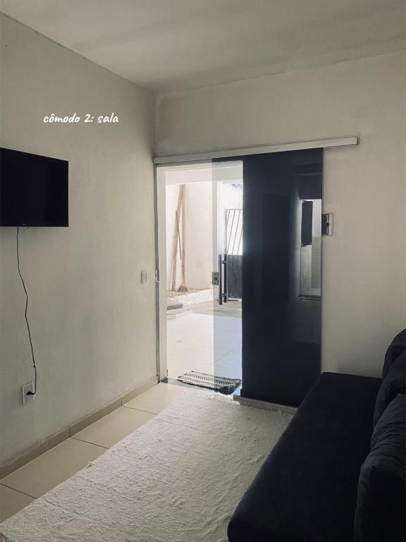 a living room with a sliding glass door with a television at Chalé Di vino in Porto Seguro